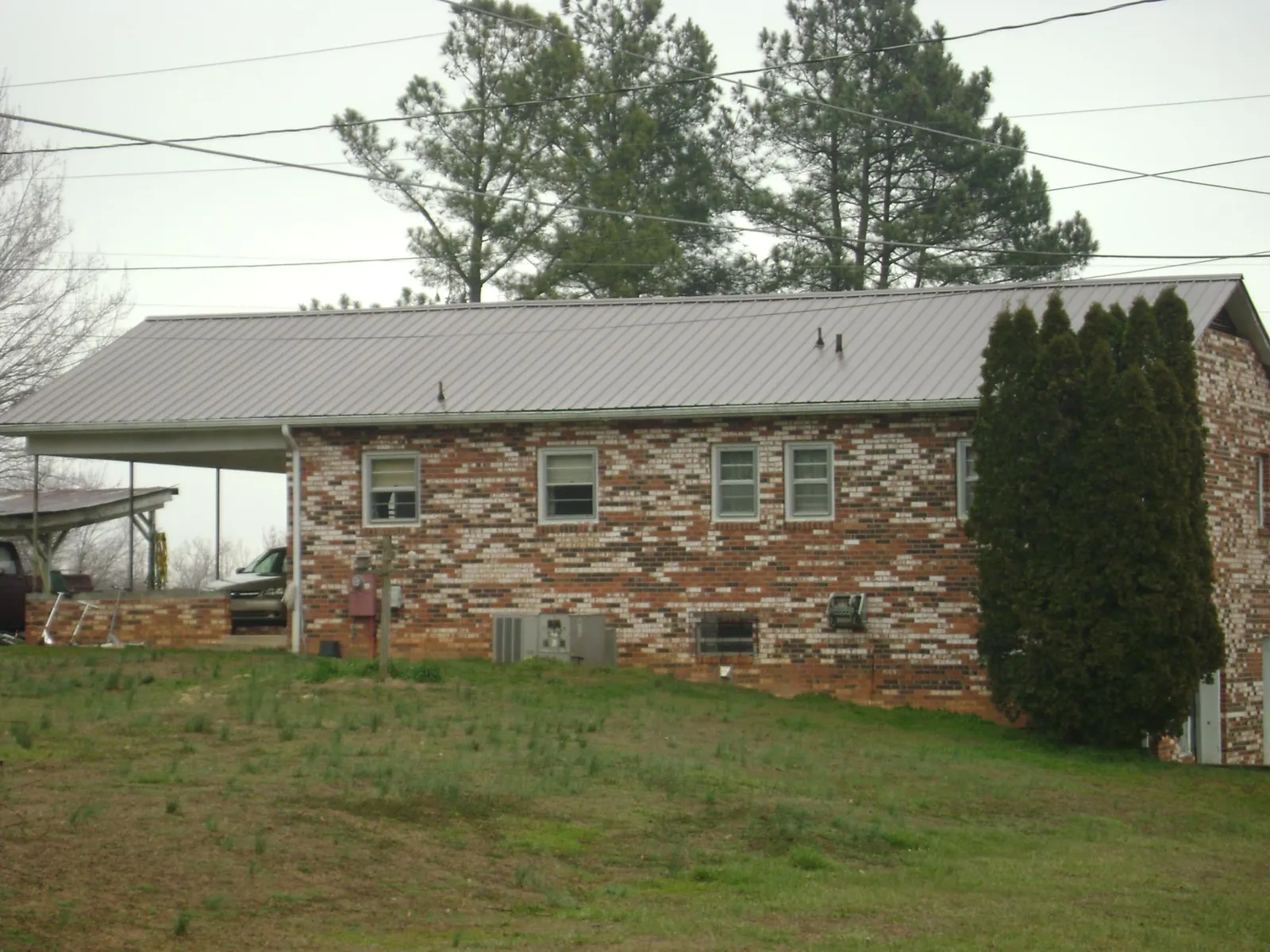 Gray metal roof on a brick split level home with a carport in Ridgeland
