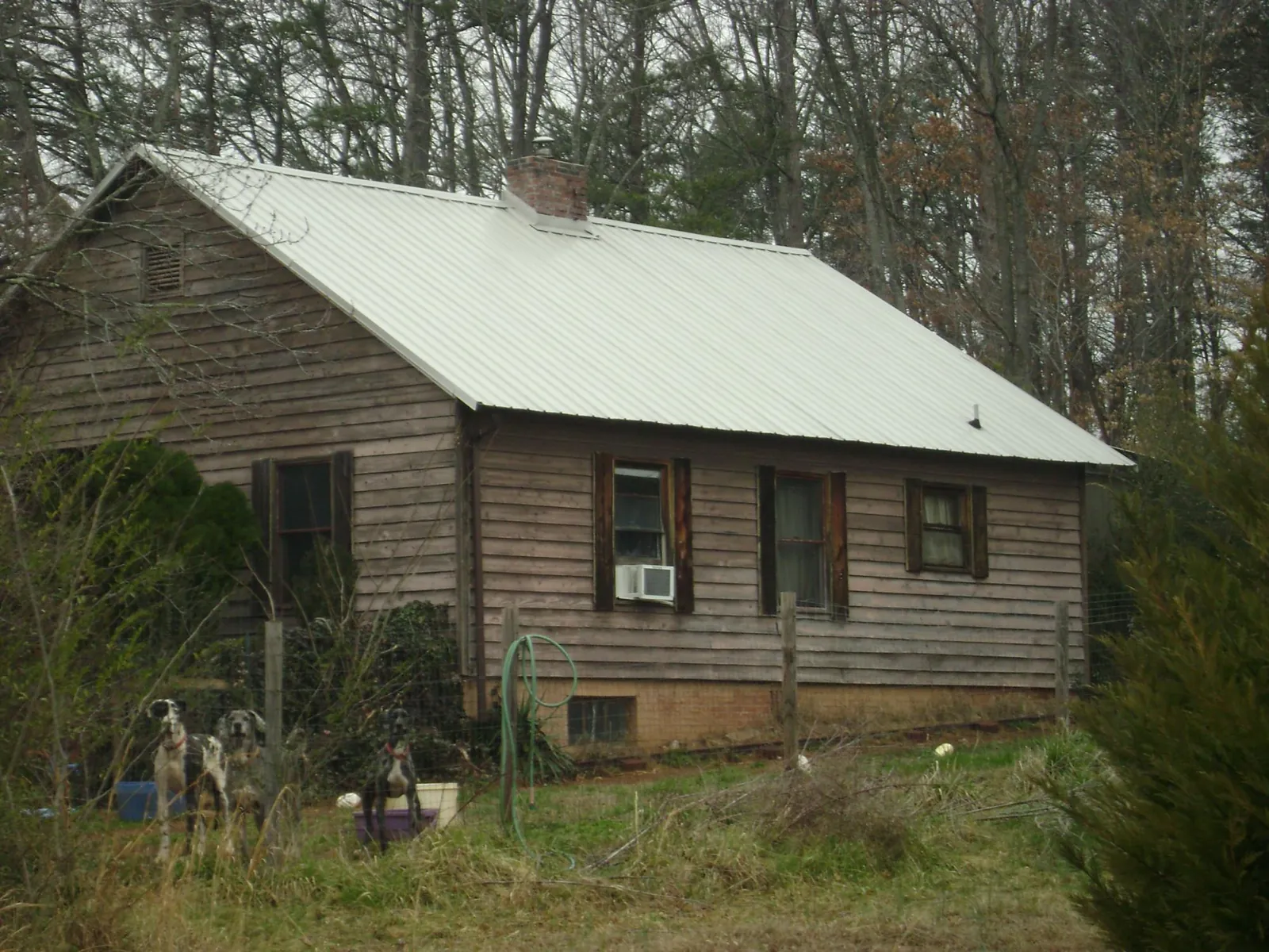 White metal roof on an old wood sided farmhouse, from a Metal Roof Installation job in Ridgeland
